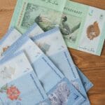 Banknoty malezyjskiego ringgita w różnych nominałach na drewnianym tle