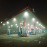 Oświetlona stacja benzynowa nocą we mgle