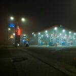 Oświetlona stacja benzynowa nocą we mgle