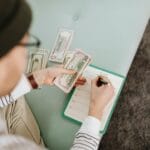 Planowanie budżetu podróży z banknotami dolarów i notesem