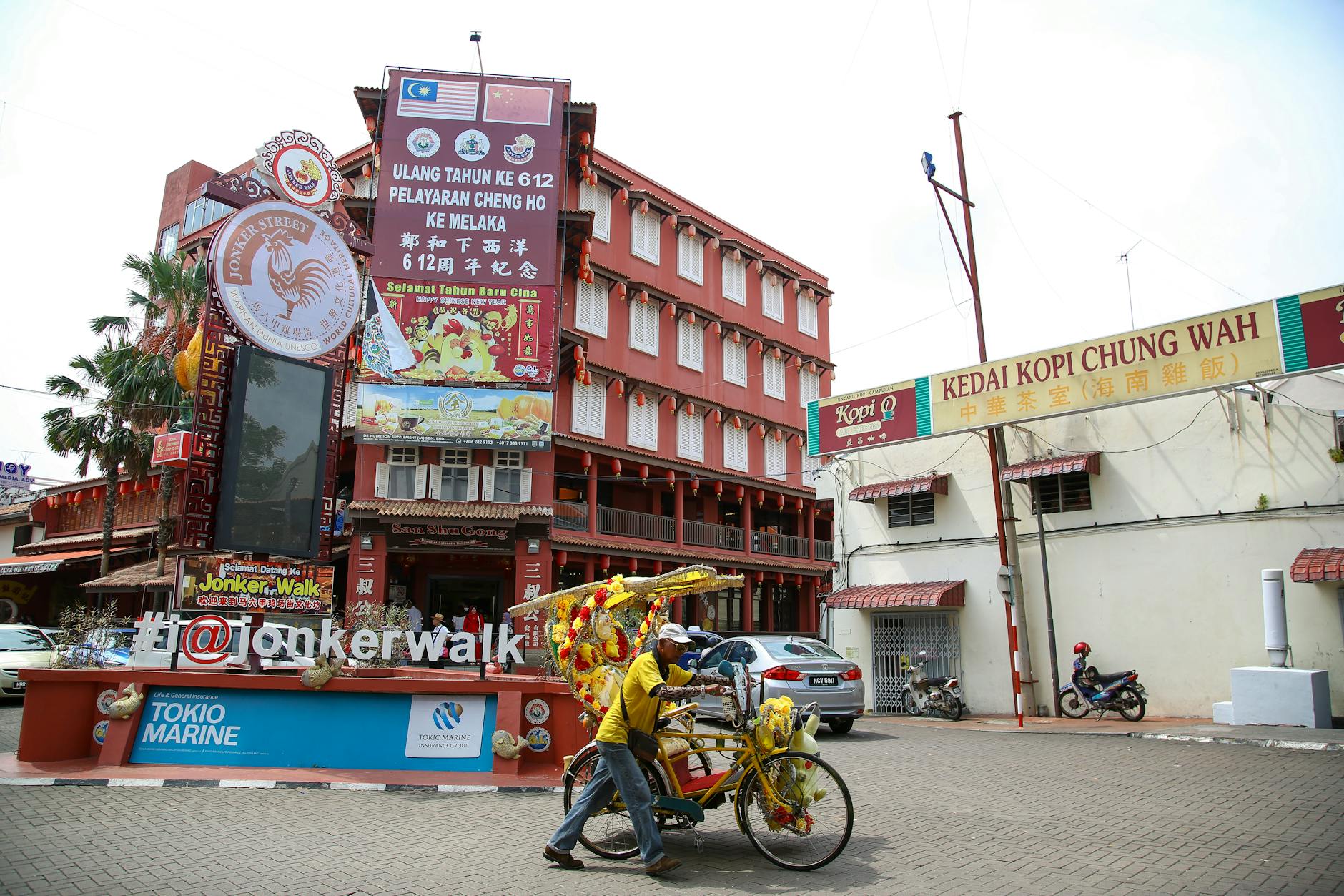 Rikszarz na kolorowym trishawie przy Jonker Street w Malacce