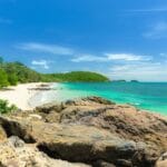 Spokojna malezyjska plaża z turkusowym morzem i zielenią pod błękitnym niebem