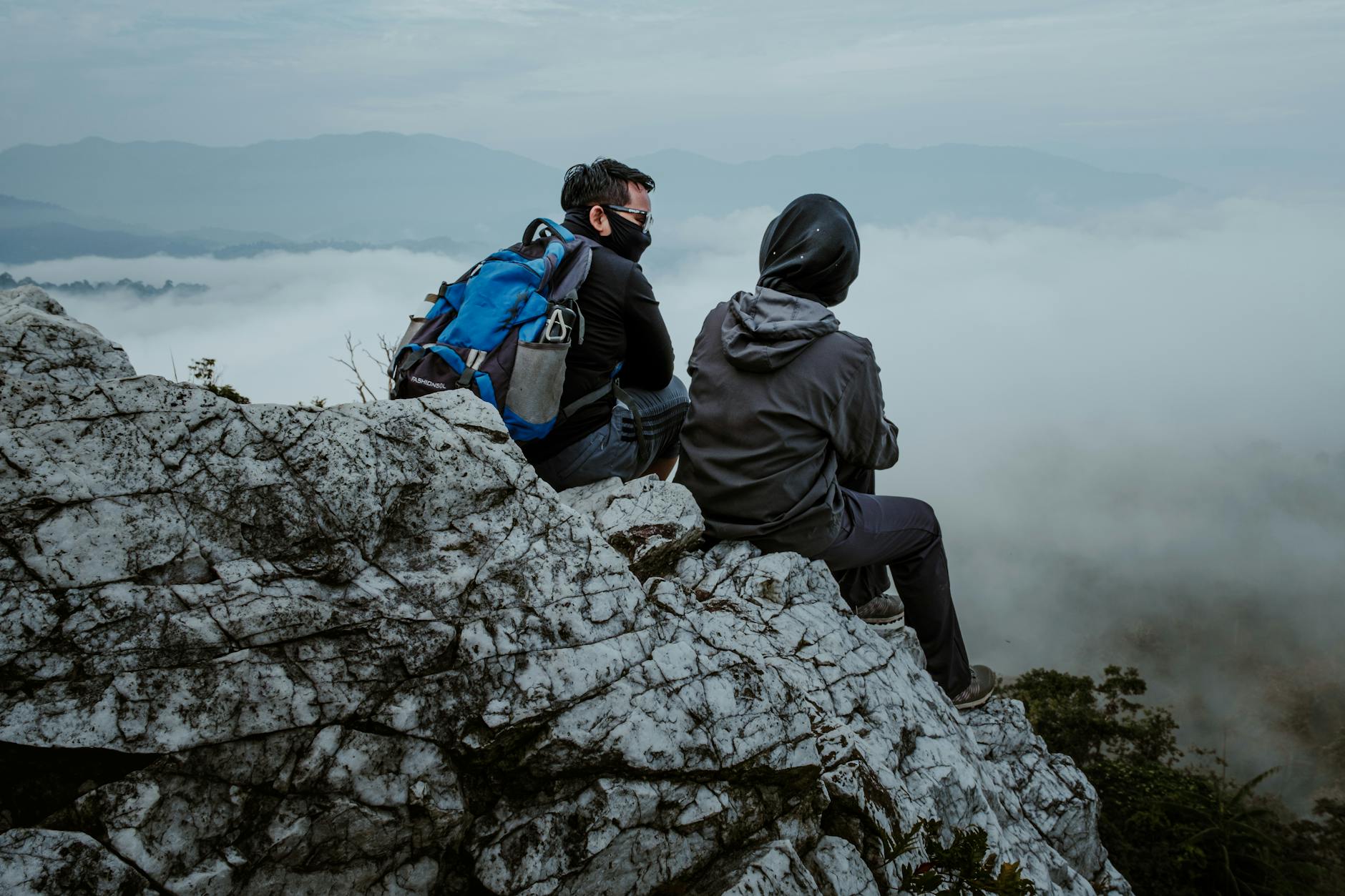 Turyści z plecakami podziwiają mglisty górski krajobraz w Malezji