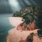 Stromy klif i las nad morzem na Borneo pod burzowym niebem