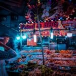 Sprzedawca przygotowuje szaszłyki z grilla na nocnym straganie w Malezji